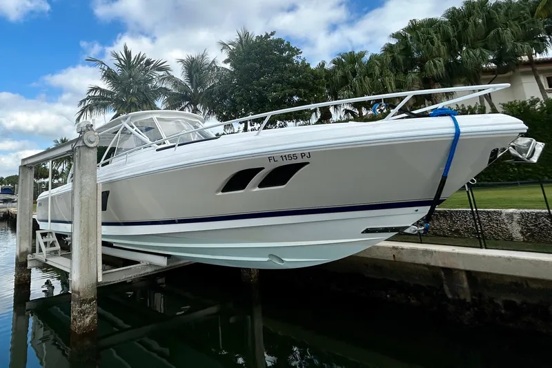  Yacht Photos Pics 2012 Intrepid 400 Cuddy boat on lift, surrounded by palm trees and water.