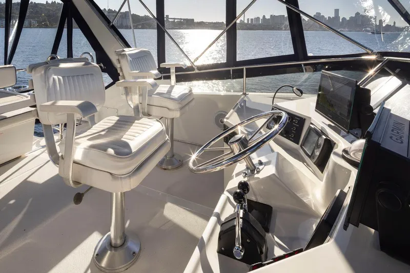 La Paz Yacht Photos Pics 1993 Tollycraft 40 Sport Sedan helm with dual captain chairs, overlooking scenic waterfront.