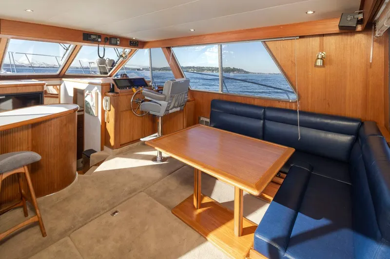 La Paz Yacht Photos Pics Interior of 1993 Tollycraft 40 Sport Sedan with blue seating and wooden table.