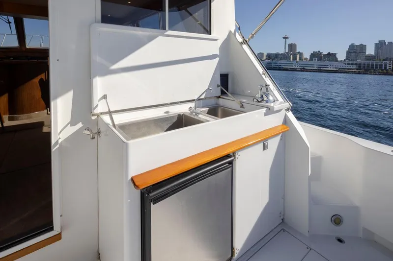 La Paz Yacht Photos Pics 1993 Tollycraft 40 Sport Sedan yacht with outdoor sink and fridge, city skyline in background.