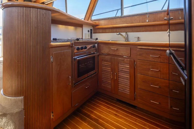 La Paz Yacht Photos Pics 1993 Tollycraft 40 Sport Sedan yacht kitchen with wooden cabinetry and modern appliances.