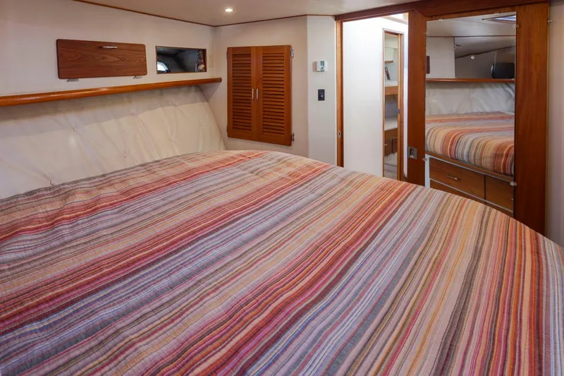 La Paz Yacht Photos Pics Interior of 1993 Tollycraft 40 Sport Sedan with striped bedding and wooden accents.