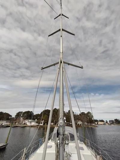 Seeker Yacht Photos Pics Sailboat mast of 2005 Stevens Custom 53/56 against cloudy sky, docked by waterfront homes.