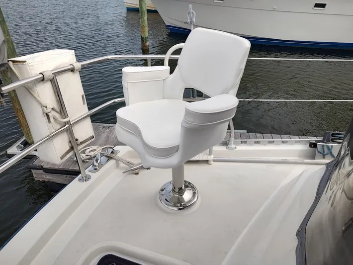 Seeker Yacht Photos Pics White captain's chair on a Stevens Custom 53/56 yacht, docked by the water.