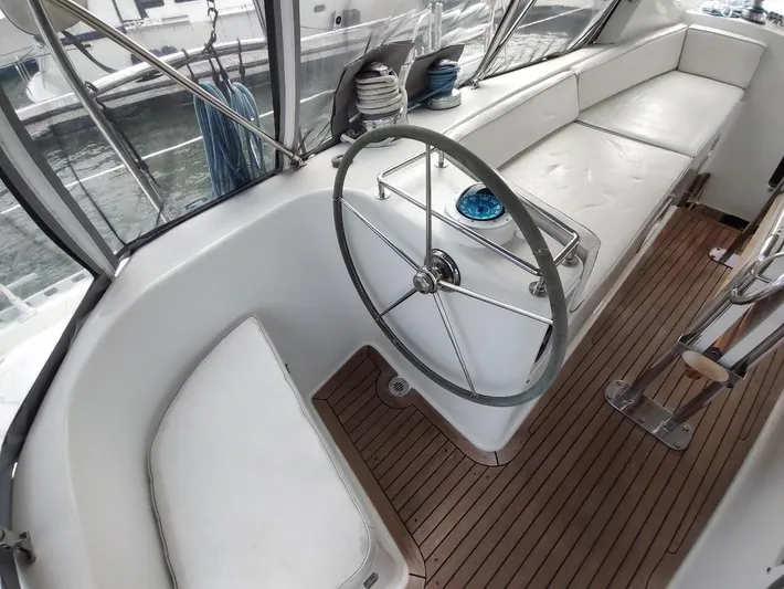 Seeker Yacht Photos Pics Stevens Custom 53/56 yacht cockpit with steering wheel, white seating, and wooden flooring, 2005 model.
