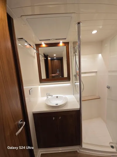 Ocean Driver Yacht Photos Pics Luxurious bathroom in 2022 Riviera 54 Enclosed Flybridge yacht with modern fixtures and wood accents.