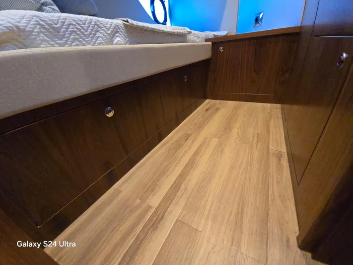 Ocean Driver Yacht Photos Pics 2022 Riviera 54 Enclosed Flybridge interior with wood flooring and storage cabinets.