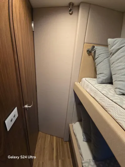 Ocean Driver Yacht Photos Pics 2022 Riviera 54 Enclosed Flybridge cabin with bunk beds and wooden accents.