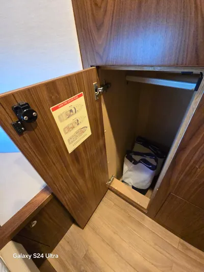 Ocean Driver Yacht Photos Pics Open wooden cabinet on Riviera 54 Enclosed Flybridge 2022 yacht interior.