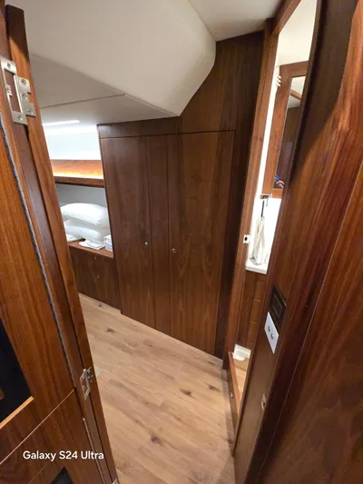 Ocean Driver Yacht Photos Pics Interior of 2022 Riviera 54 Enclosed Flybridge with wooden cabinetry and flooring.