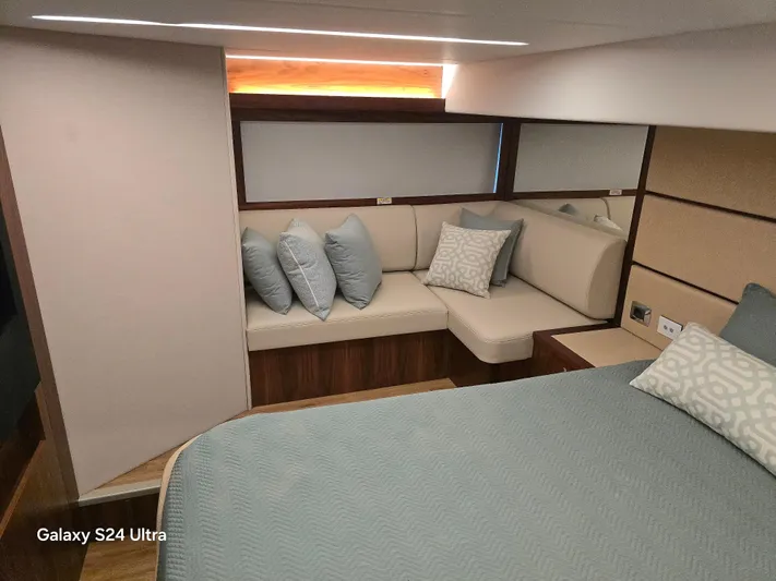 Ocean Driver Yacht Photos Pics Luxurious interior of 2022 Riviera 54 Enclosed Flybridge with elegant seating and bedding.