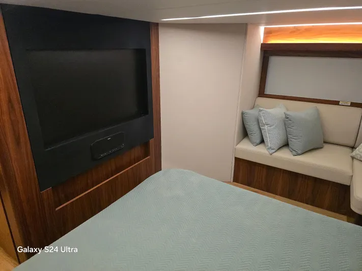 Ocean Driver Yacht Photos Pics Interior of 2022 Riviera 54 Enclosed Flybridge with TV and seating area.
