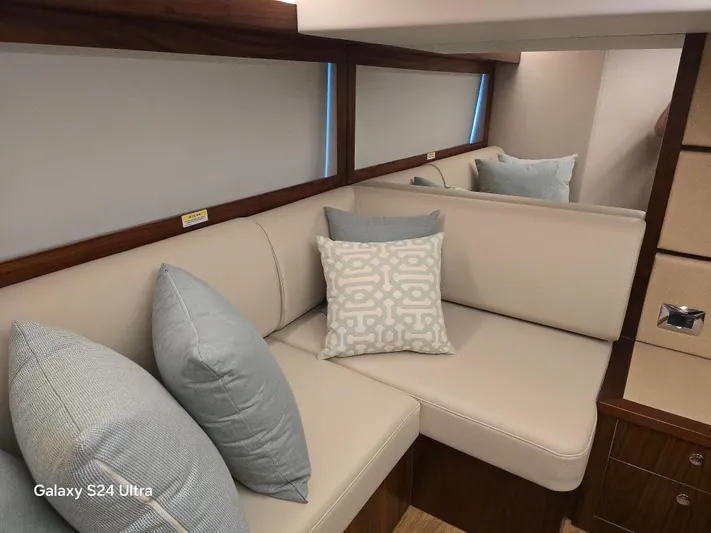 Ocean Driver Yacht Photos Pics Luxurious interior of 2022 Riviera 54 Enclosed Flybridge with elegant cushions and seating.