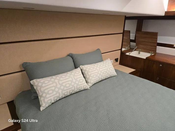 Ocean Driver Yacht Photos Pics Luxurious bedroom interior of 2022 Riviera 54 Enclosed Flybridge yacht with elegant bedding.