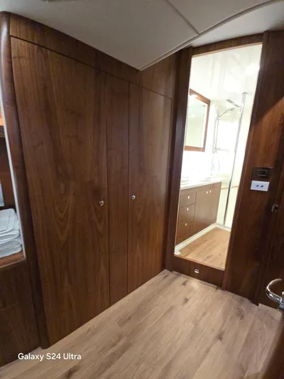 Ocean Driver Yacht Photos Pics Interior of 2022 Riviera 54 Enclosed Flybridge with wooden cabinetry and modern bathroom.