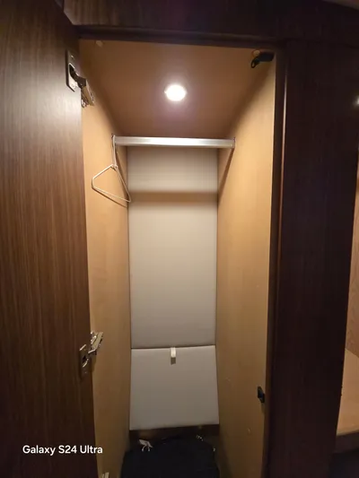 Ocean Driver Yacht Photos Pics Closet interior in 2022 Riviera 54 Enclosed Flybridge yacht, wooden finish, overhead light.