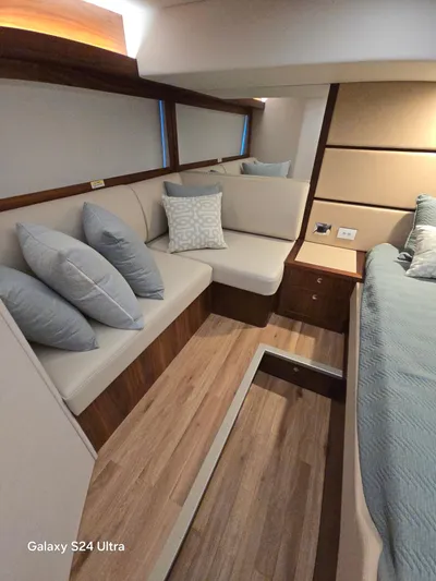 Ocean Driver Yacht Photos Pics 2022 Riviera 54 Enclosed Flybridge interior with modern seating and elegant wood flooring.