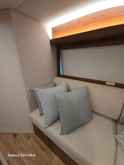 Ocean Driver Yacht Photos Pics Interior of 2022 Riviera 54 Enclosed Flybridge with cushioned seating and pillows.