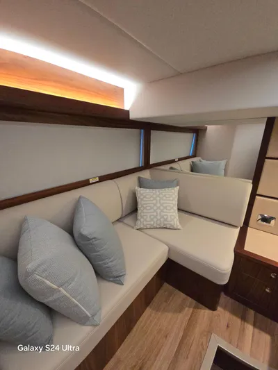Ocean Driver Yacht Photos Pics Interior of 2022 Riviera 54 Enclosed Flybridge with cozy seating and decorative pillows.