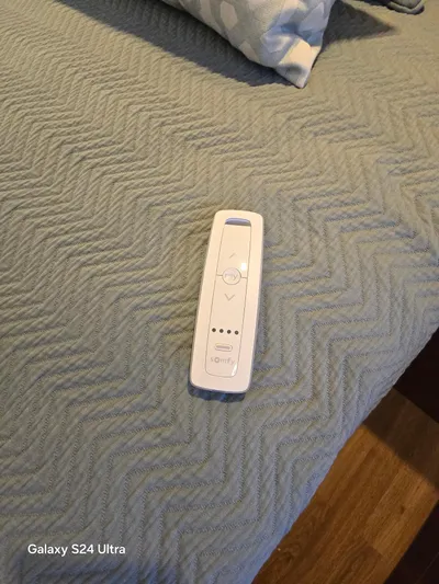 Ocean Driver Yacht Photos Pics Remote control on a textured blue bedspread, Galaxy S24 Ultra photo.