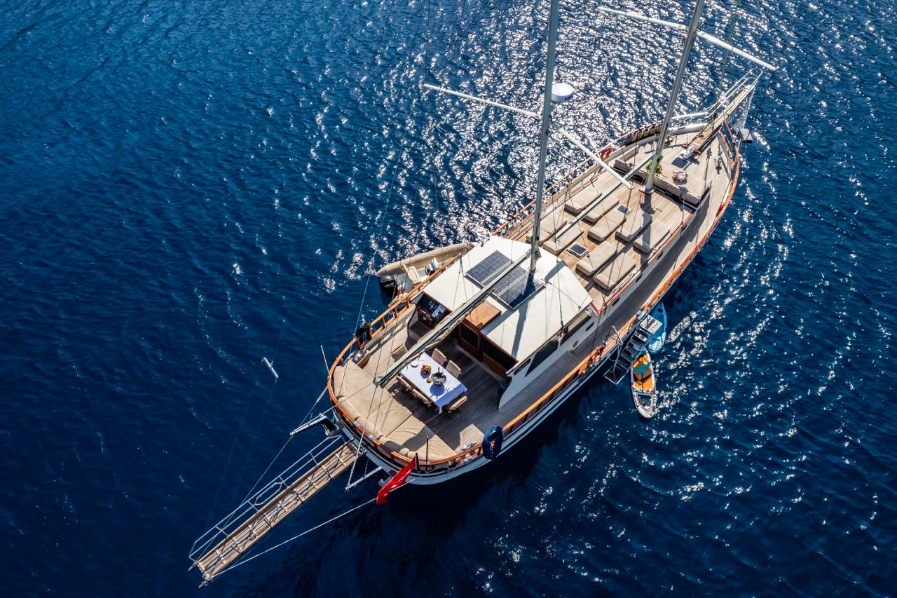Aerial view of a custom 1990 sailboat on deep blue water.