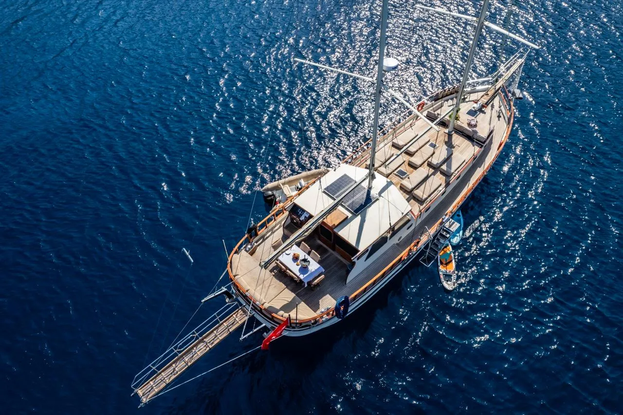 Aerial view of a custom 1990 sailboat on deep blue water.