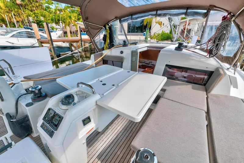 Dantari Yacht Photos Pics 2021 Jeanneau Sun Odyssey 440 cockpit with seating, table, and navigation instruments.
