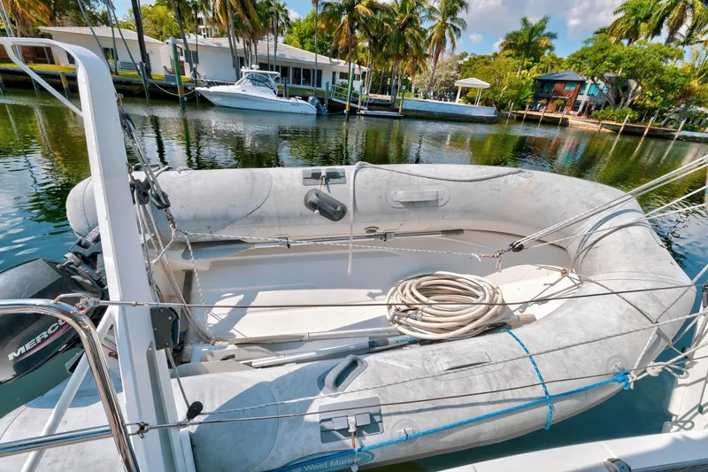 Dantari Yacht Photos Pics Inflatable dinghy on Jeanneau Sun Odyssey 440 yacht, docked by waterfront homes, 2021 model.