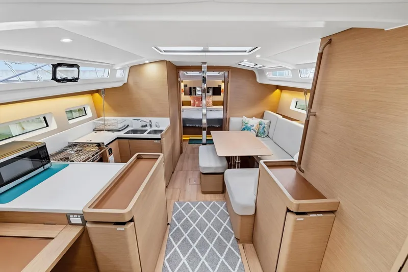Dantari Yacht Photos Pics Interior of 2021 Jeanneau Sun Odyssey 440 yacht, featuring modern kitchen and cozy seating area.