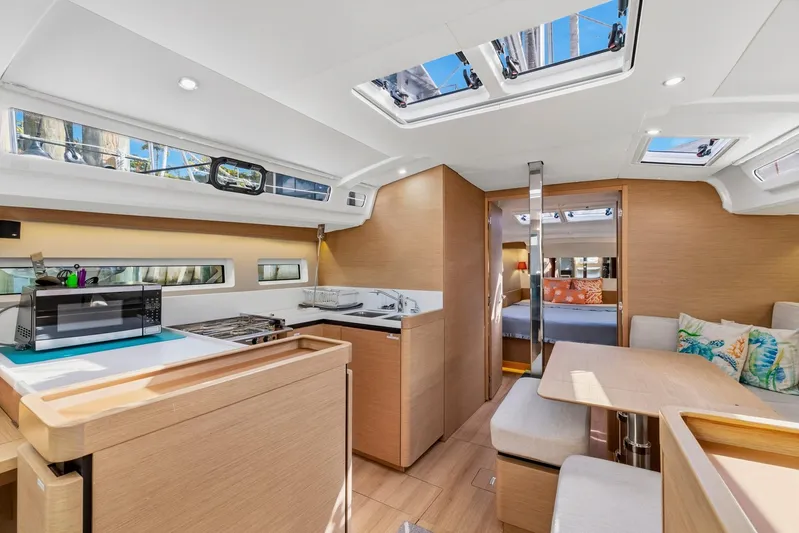 Dantari Yacht Photos Pics Interior of 2021 Jeanneau Sun Odyssey 440 yacht, featuring modern kitchen and cozy seating area.