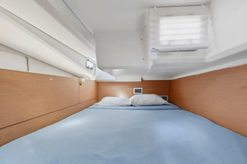 Dantari Yacht Photos Pics Cozy cabin interior of 2021 Jeanneau Sun Odyssey 440 sailboat with a comfortable bed.