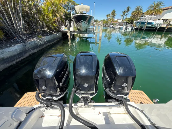  Yacht Photos Pics Three powerful outboard motors on a 2013 Intrepid 390 Sport Yacht, docked in a scenic marina.
