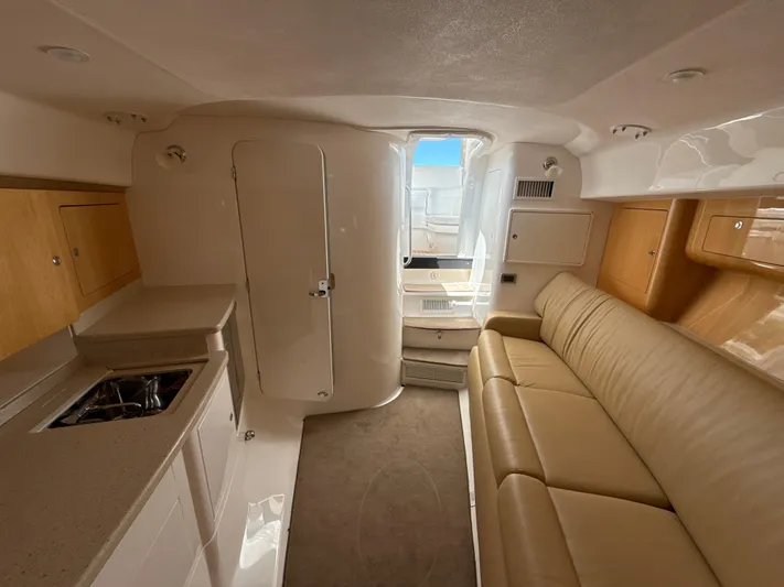  Yacht Photos Pics Interior of 2013 Intrepid 390 Sport Yacht with beige leather seating and compact kitchenette.