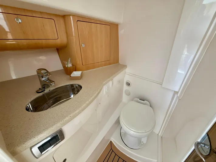  Yacht Photos Pics 2013 Intrepid 390 Sport Yacht bathroom with sink, toilet, and wooden cabinetry.