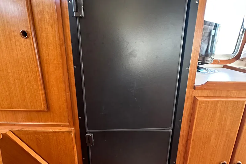 S.k.i Yacht Photos Pics Interior of 2000 Eagle 40 Pilothouse Trawler with wooden cabinetry and black door.