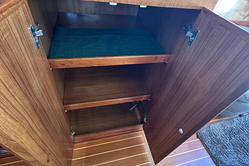 S.k.i Yacht Photos Pics Wooden cabinet interior on 2000 Eagle 40 Pilothouse Trawler, featuring shelves and open door.