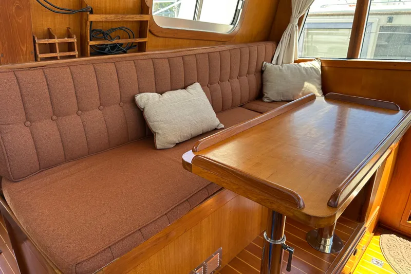 S.k.i Yacht Photos Pics Cozy interior of 2000 Eagle 40 Pilothouse Trawler with wooden table and cushioned seating.