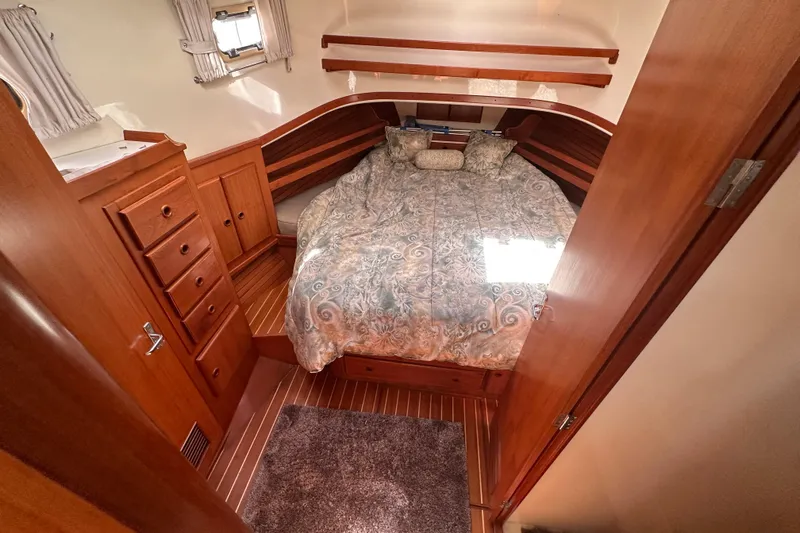 S.k.i Yacht Photos Pics Cozy bedroom in 2000 Eagle 40 Pilothouse Trawler with wood cabinetry and patterned bedding.