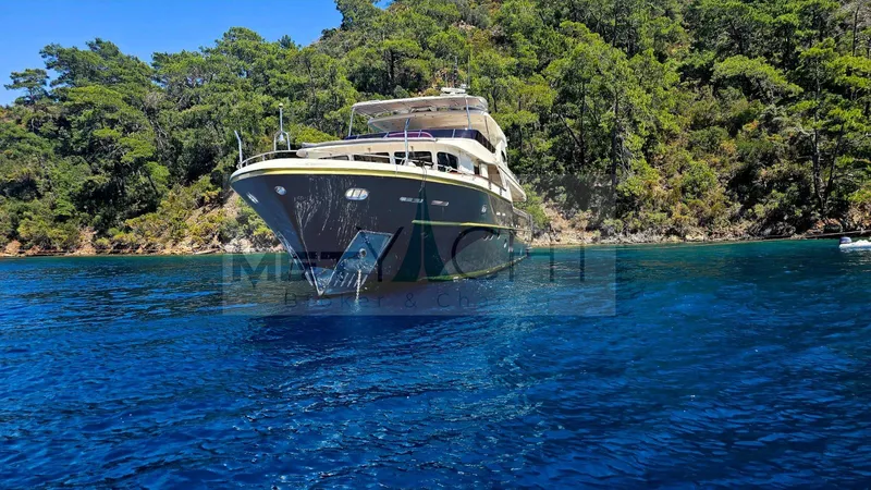  Yacht Photos Pics Luxury Ses Yachts 100, 2010 model, anchored in clear blue waters near lush greenery.