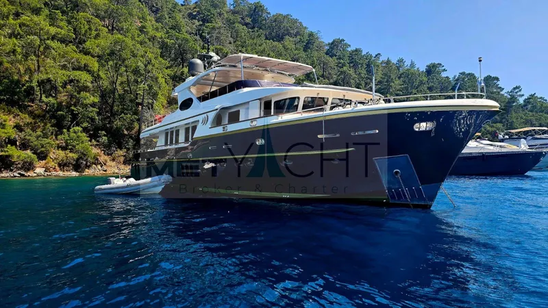  Yacht Photos Pics Luxurious 2010 Ses Yachts 100 moored in serene, clear blue waters near lush greenery.