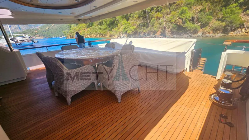  Yacht Photos Pics Luxurious Ses Yachts 100 deck with wicker furniture, overlooking serene waters and lush greenery.