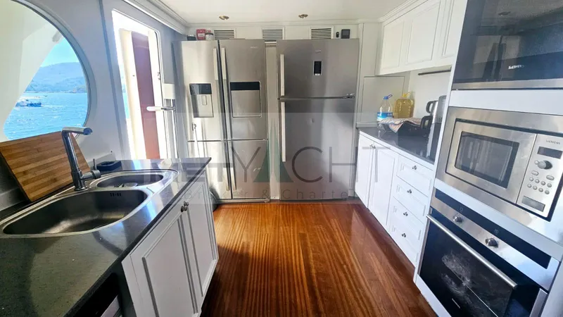  Yacht Photos Pics Modern kitchen interior on 2010 Ses Yachts 100, featuring stainless steel appliances and wooden flooring.