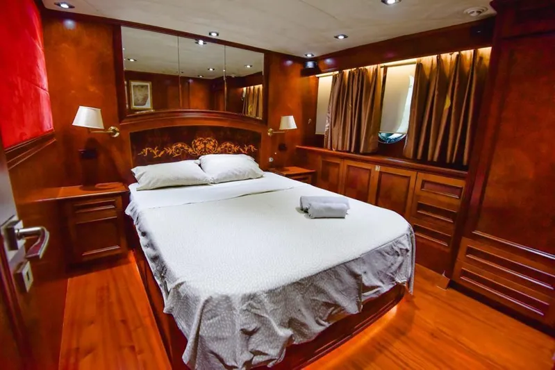  Yacht Photos Pics Luxurious bedroom interior on 2010 Ses Yachts 100, featuring elegant wood paneling and cozy bedding.