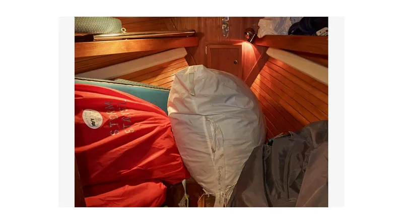  Yacht Photos Pics Interior of 1983 Valiant 40 Selah sailboat with stored sails and wooden paneling.