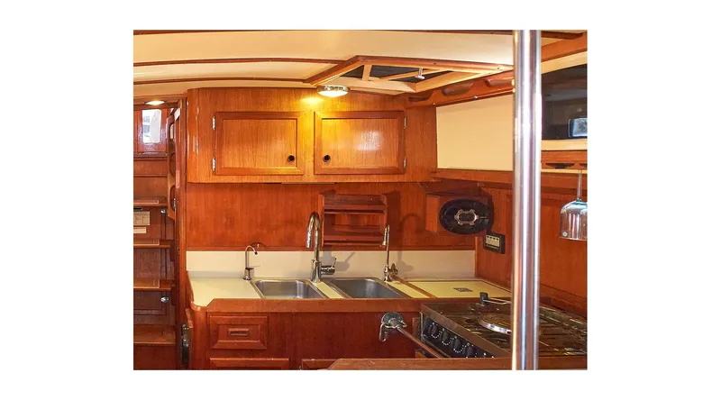  Yacht Photos Pics 1983 Valiant 40 Selah yacht interior kitchen with wooden cabinets and dual sinks.