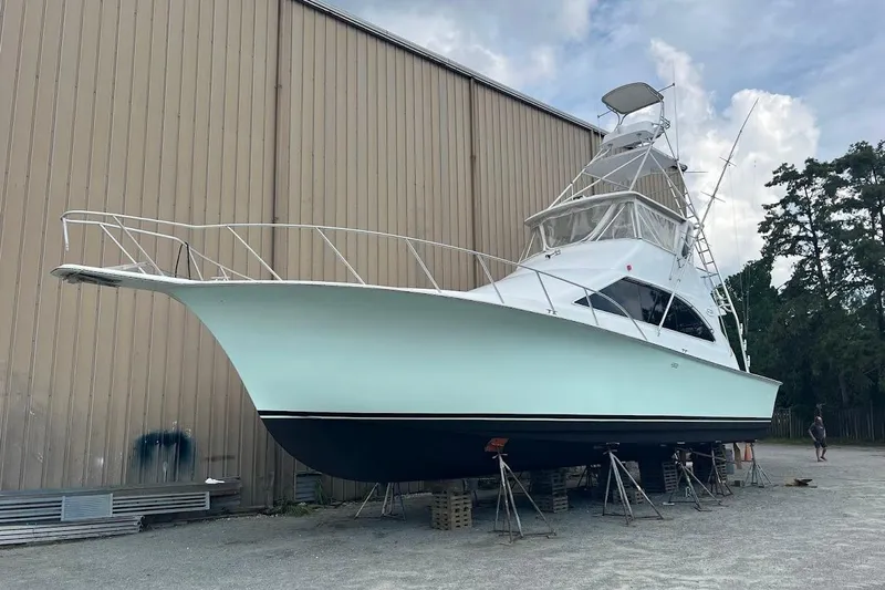 Top Pryority Yacht Photos Pics 1996 Ocean Yachts 48 Super Sport boat on stands, near a large building.