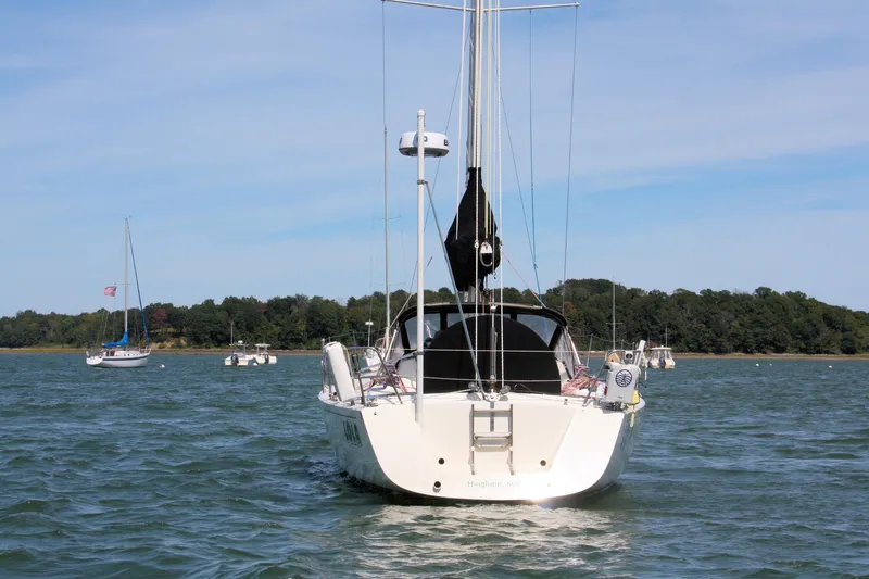 Lola Yacht Photos Pics Sailboat J/130 from 1995 on water, surrounded by other boats and trees.