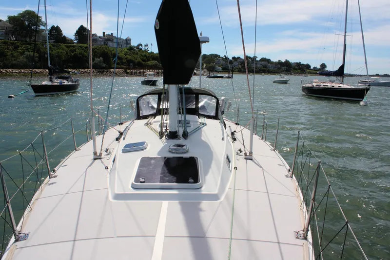 Lola Yacht Photos Pics Sailboat J/130 from 1995 on water, surrounded by other boats and scenic shoreline.