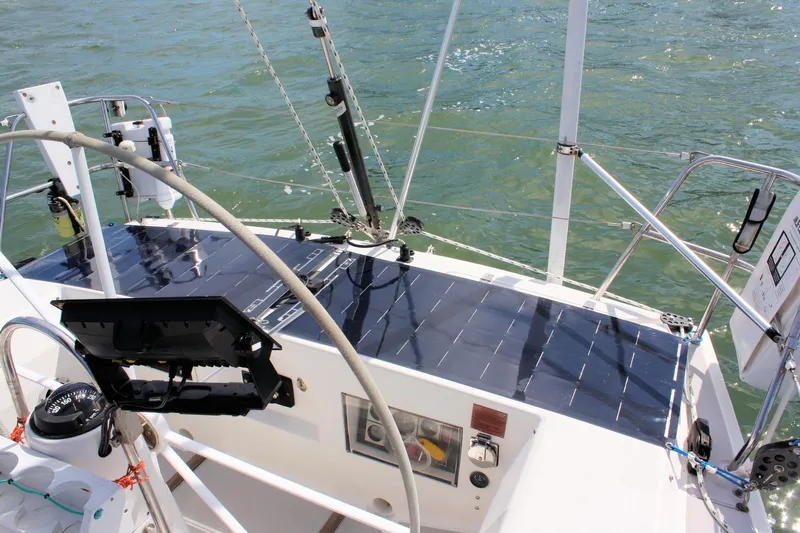 Lola Yacht Photos Pics 1995 J Boats J/130 sailboat with solar panels on deck, navigating calm waters.