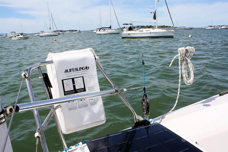 Lola Yacht Photos Pics Sailboat deck view with Lifesling, surrounded by anchored boats on the water.
